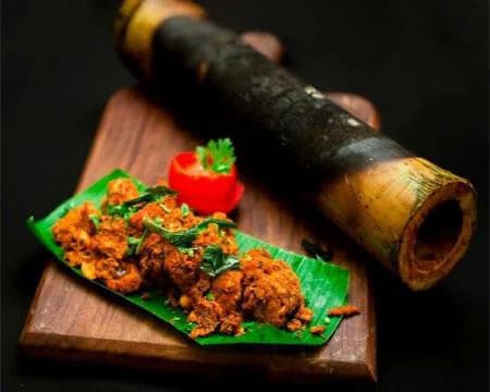 Seasoned chicken cooking inside a fresh bamboo tube