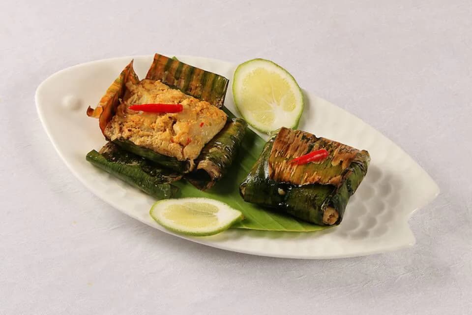 Banana-leaf parcels of fish hebang on a plate
