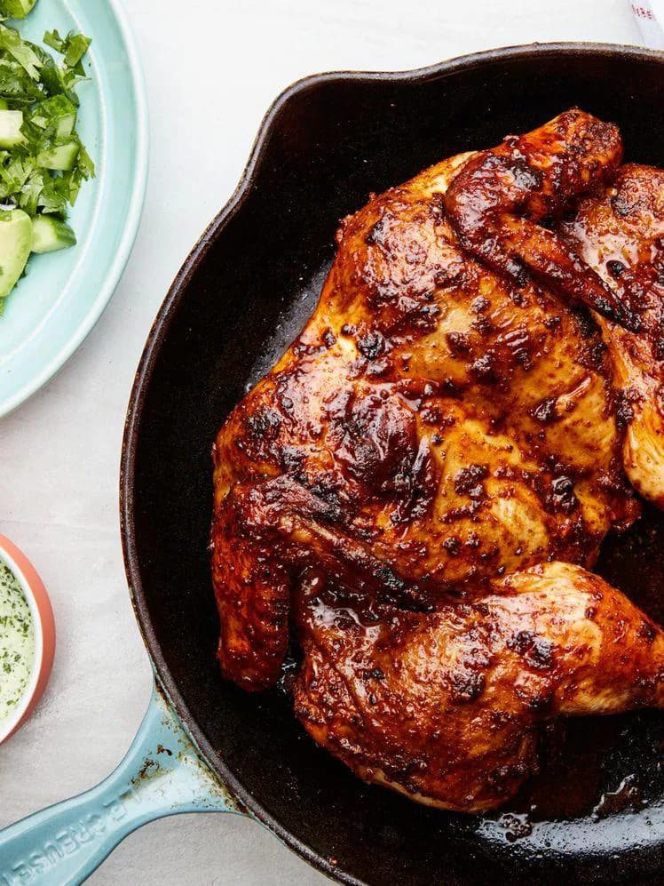A burnished whole chicken roast on a serving platter