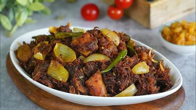 Dark beef bhuna garnished with fresh green chillies